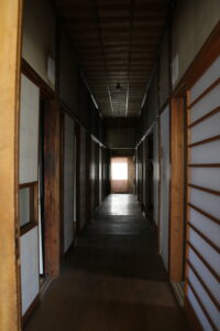 和室が並ぶ旧高野寫眞舘1階の廊下。時代を感じさせる静かな佇まい。 旧高野寫眞舘1階にある和風建築の長い廊下と和室の並ぶ様子