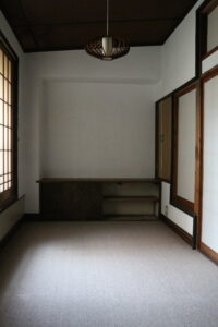 障子と洋風照明が調和する和洋折衷の居室。造り付けの机も当時のまま残されています。 旧高野寫眞舘2階にある和洋折衷の居室と造り付け机、障子窓のある空間