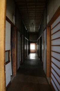 和室が並ぶ旧高野寫眞舘1階の廊下。時代を感じさせる静かな佇まい。 旧高野寫眞舘1階にある和風建築の長い廊下と和室の並ぶ様子