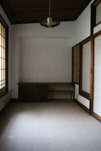 障子と洋風照明が調和する和洋折衷の居室。造り付けの机も当時のまま残されています。 旧高野寫眞舘2階にある和洋折衷の居室と造り付け机、障子窓のある空間