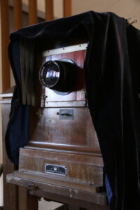 浅沼商会製「KING」ブランドの大型カメラ。レンズはFUJINAR製で、当時のプロ機材の代表格。 旧高野寫眞舘に現存する浅沼商会製の蛇腹式大型カメラとFUJINARレンズのアップ