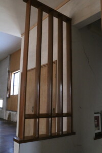 スタジオ入口に設けられた木製の縦格子。視線を通しながら空間を柔らかく分ける役割を果たします。 旧高野寫眞舘2階スタジオ入口にある縦格子の木製パーティション